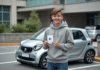 Jeune garçon avec permis B devant une microcar en ville